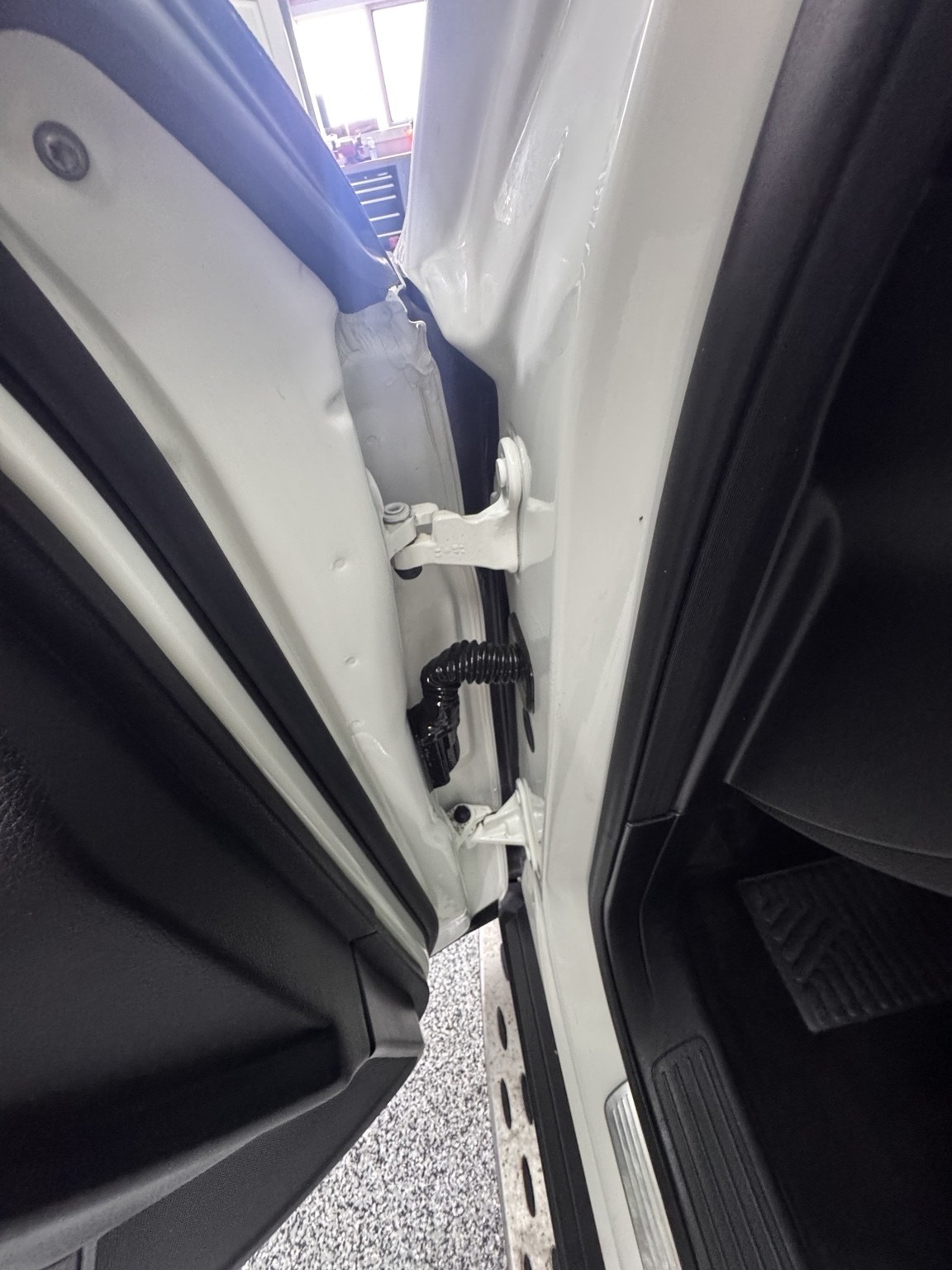 After detailing: cleaned white vehicle door hinge and jamb