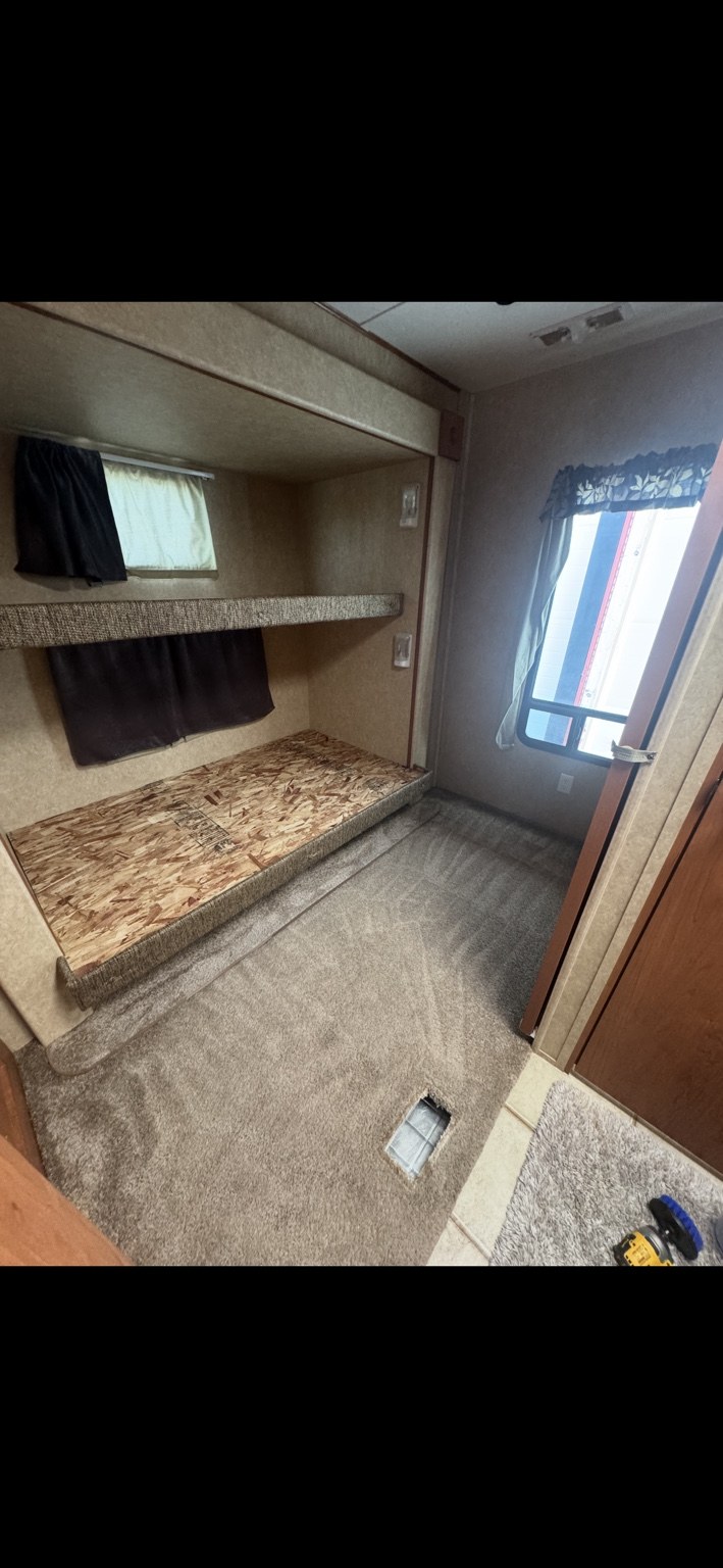 RV bunk area and carpet after cleaning, with mattresses removed