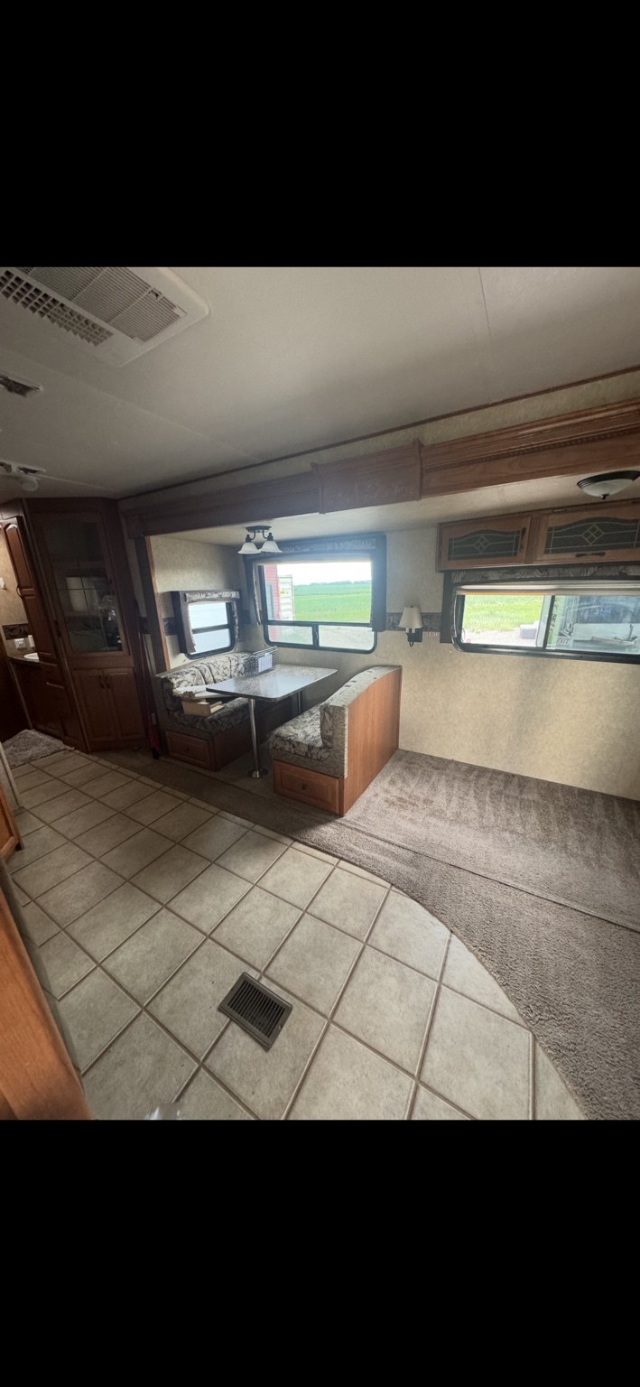 RV living and dining areas after interior cleaning, with tile and carpet flooring